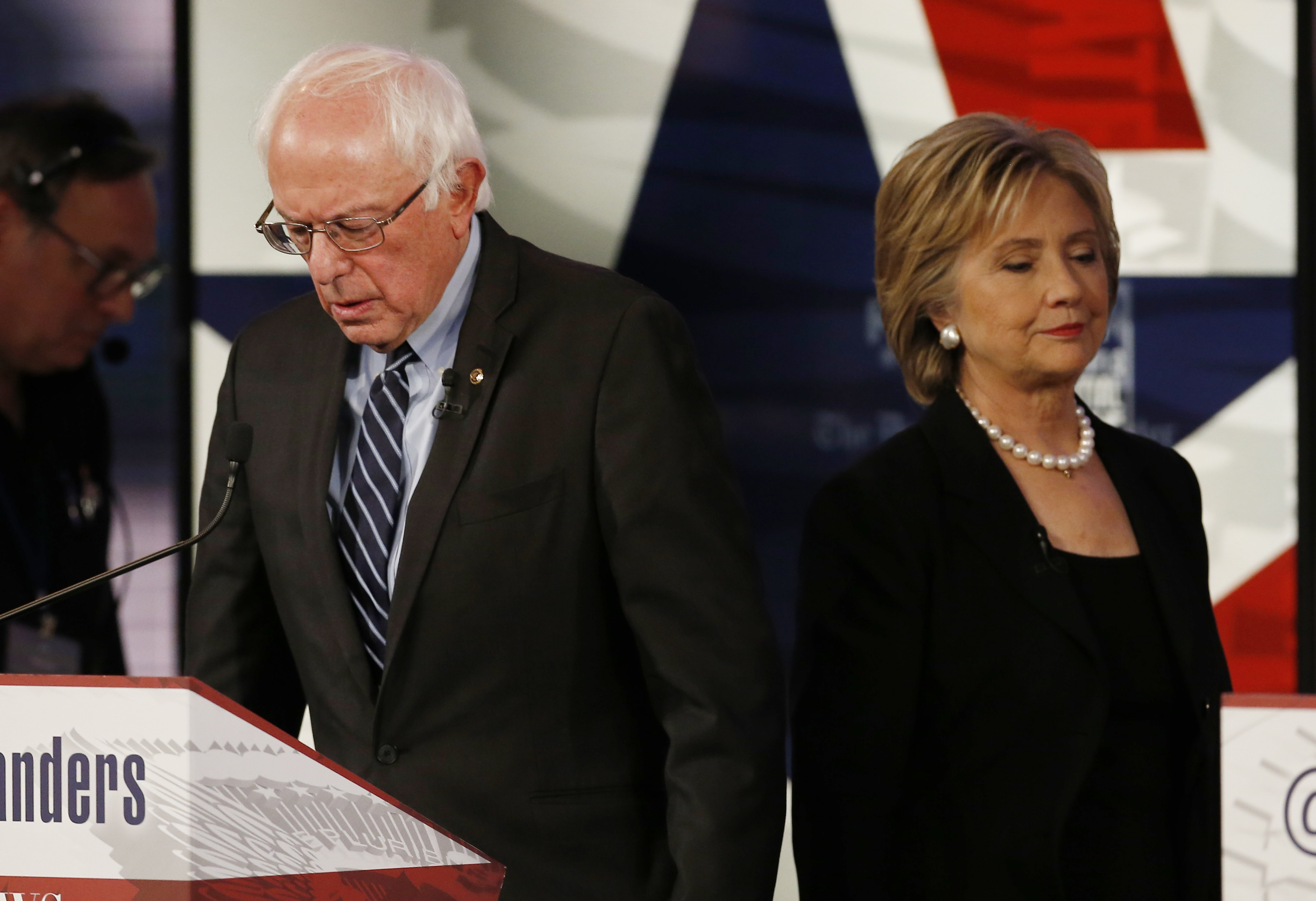 Democratic U.S. presidential candidate Clinton walks past Sanders during a break at the second official 2016 U.S. Democratic presidential candidates debate in Des Moines